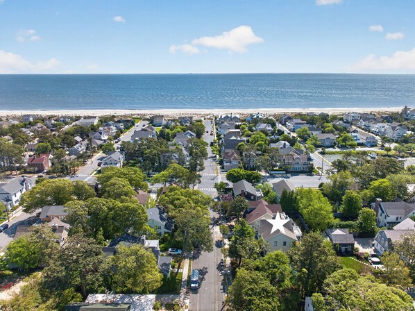 A coastal residential area with houses, streets, and a beach.