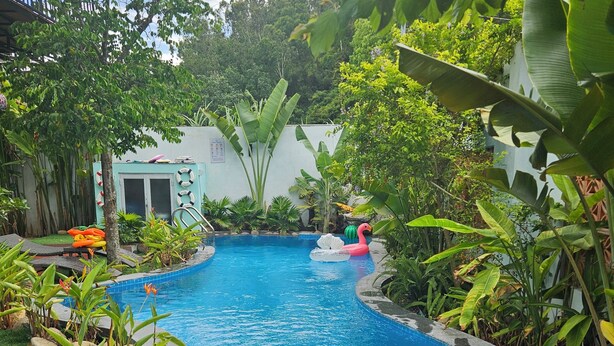 A swimming pool surrounded by tropical plants and a small building with a door. - Peaceful villa Đà Nẵng-Sơn Trà Moutain view-2bedroom -Pool- Nearbeach- Steambath (Đà Nẵng)