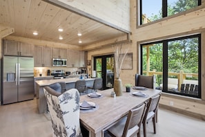Une cuisine moderne avec des meubles en bois, des appareils en acier inoxydable et un grand îlot central.