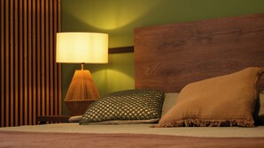 A bed with a wooden headboard, a bedside lamp, and two pillows. - Alma Terra Campestre (Ginebra)