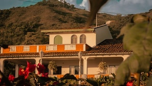 A building with a tiled roof, a balcony, and a satellite dish. - Alma Terra Campestre (Ginebra)
