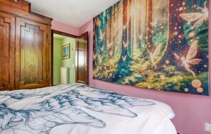 A bedroom with a large bed, a wardrobe, a door leading to another room, and a forest-themed wall tapestry. - 3 bedroom stunning home in Rezzoaglio (Rezzoaglio)