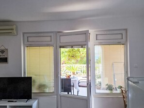 Ein Zimmer mit Fernseher auf einem Schrank, einer Tür zum Ausgang und einem Schild, das kostenloses WLAN anzeigt.