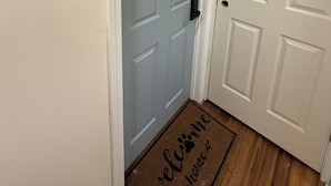 A hallway with a light blue door and a white door, both with simple panel designs.