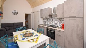 Una cucina funzionale con tavolo, sedie, piano cottura e frigorifero.
