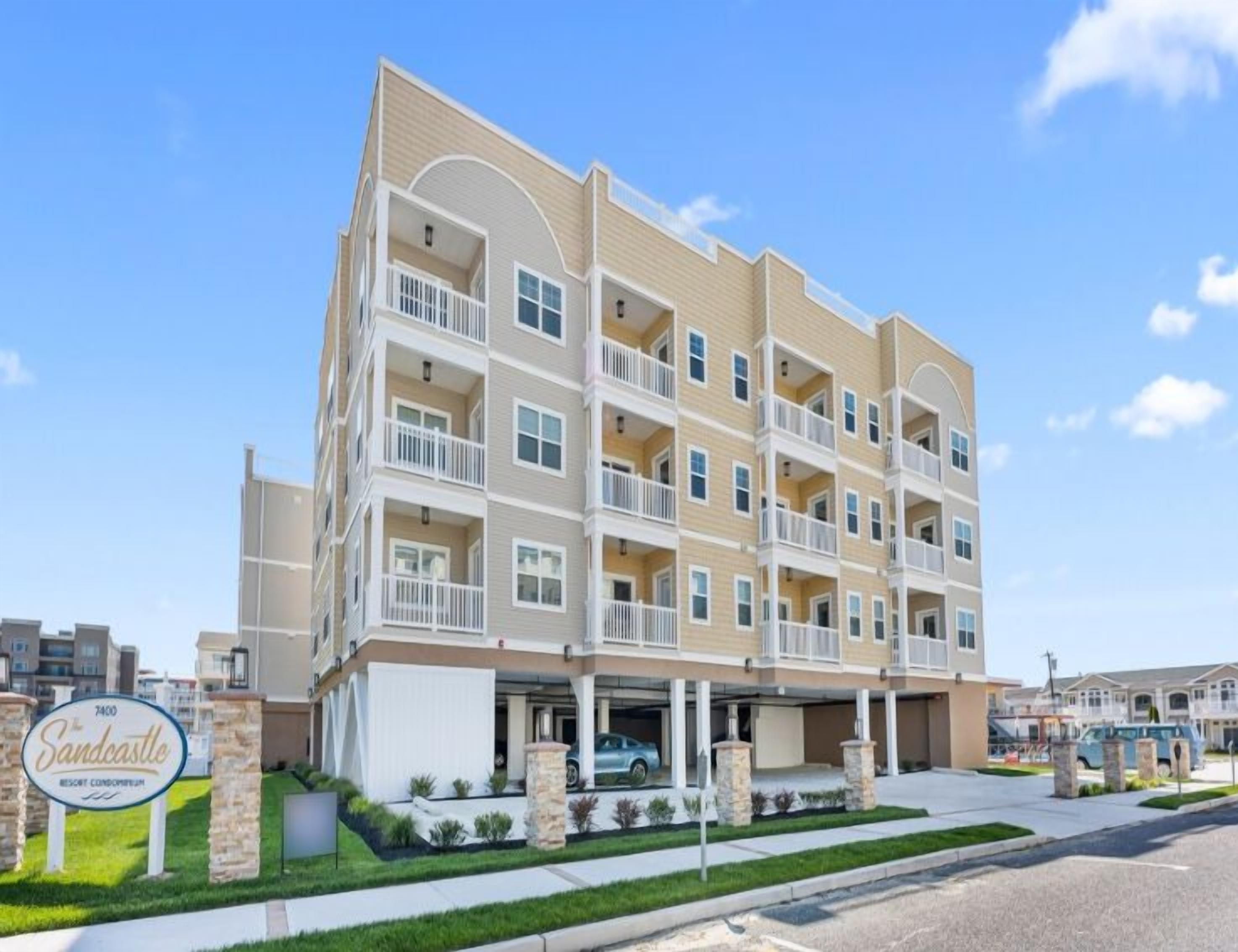 Un hôtel à plusieurs étages doté d’une cour intérieure, de balcons et d’une enseigne indiquant qu’il s’agit d’un complexe hôtelier proposant des appartements en copropriété.