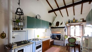 A kitchen with a stove, oven, and green cabinets. - La Duchessa Tenuta Donna Olga (Porrona)