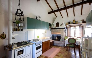 Una cocina con estufa, horno y armarios verdes.