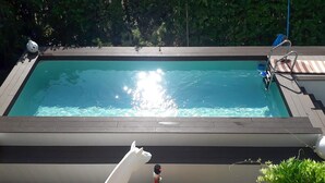 A rectangular swimming pool with a wooden deck and steps leading into the water. - La Duchessa Tenuta Donna Olga (Porrona)