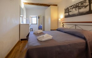 A bedroom with a bed, a desk, and a chair.