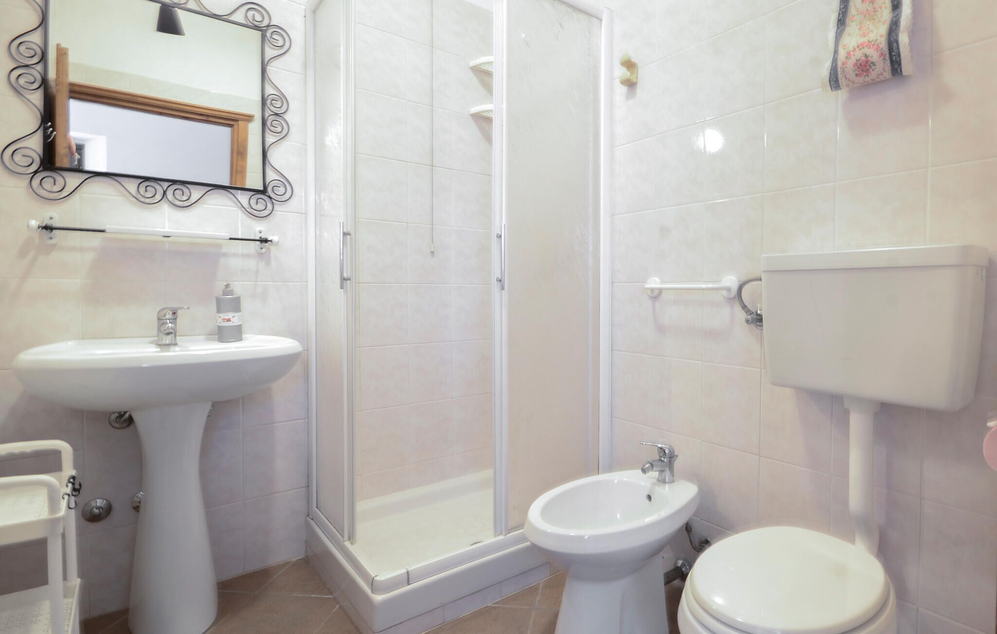 A bathroom with a shower, sink, and toilet.