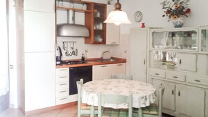 Une cuisine équipée d’une cuisinière, d’un évier et d’une table à manger avec des chaises.