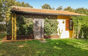 A single-story house with a tiled roof, a door with a metal gate, and a small window with shutters. - 2 bedroom stunning home in Monteverdi Marittimo (Monteverdi Marittimo)