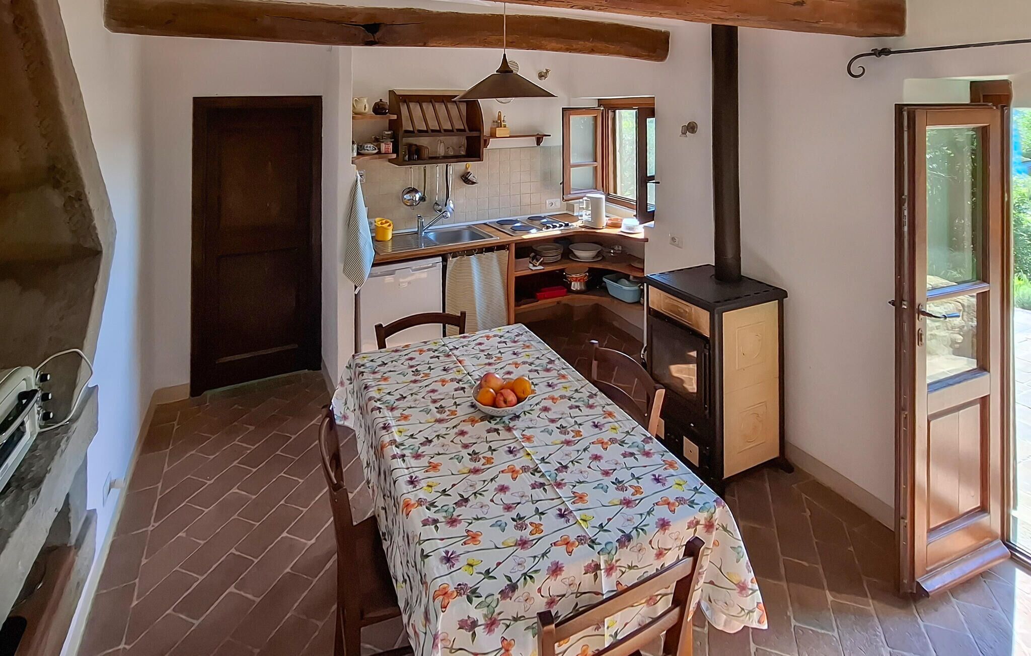 Una cocina rústica con una mesa de comedor, una estufa y un ventanal.