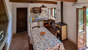 Une cuisine rustique avec une table à manger, un poêle et une fenêtre.