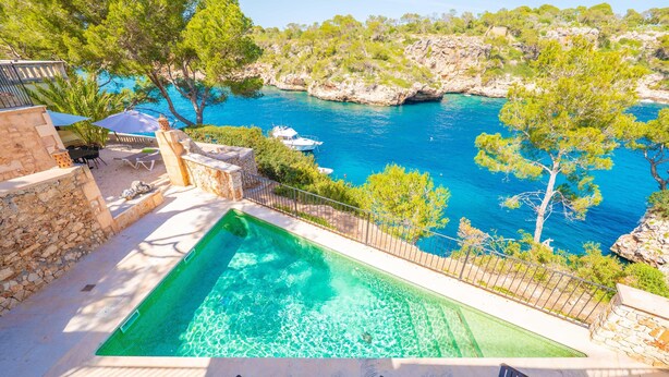 A pool with a view of the sea, outdoor seating, and a stone wall. - VILLA CALA FIGUERA - Villa with private pool, direct access to the sea and free Wi-Fi (Santanyí)