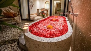 Wellnessbereich mit Whirlpool, umgeben von Rosenblättern, eine Sitzecke mit Sofa und Sesseln sowie ein Blick ins Innere.