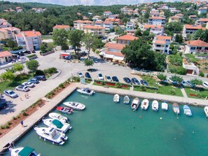 Uma marina com barcos atracados, rodeada por edifícios residenciais com telhados vermelhos.