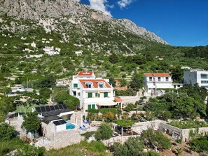 A hillside residential area with houses, a swimming pool, and solar panels. - Fewo mit gemeinschaftlichem Pool by Interhome (Drašnice)