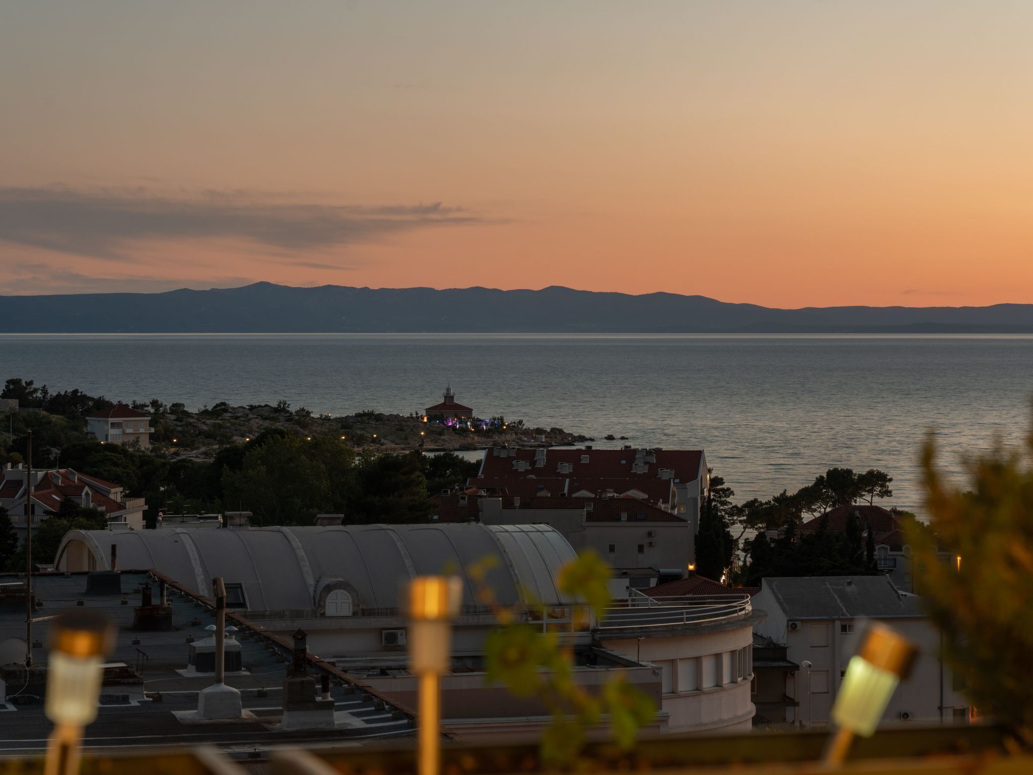 Un pueblo costero al atardecer, con edificios y una masa de agua.
