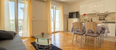 A modern apartment with a living room, dining area, and kitchen.