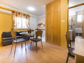 A compact living space with a dining area, sofa, and wooden wardrobe. - Apartment Raspolic no.1 by Interhome (Opatija/Kastav)