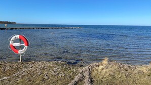A lifebuoy on a rocky shore with a clear view of the water and a distant pier. - 2 bedroom beautiful home in Färjestaden (Färjestaden)