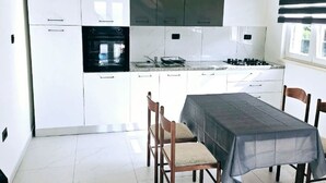 Geladeira, fogão, talheres/pratos/utensílios de cozinha