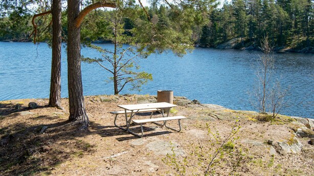 A picnic table and chair by a lake with trees in the background. - Nice home in Brottby with house a panoramic view (Brottby)