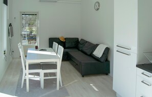A compact living space with a dining table, a sofa, a small kitchen area, and a view through a door. - 1 bedroom beautiful home in Brottby (Brottby)