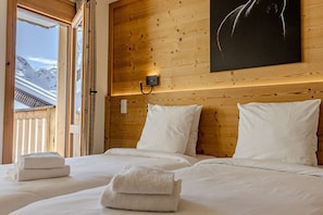 Ein Schlafzimmer mit Holzwandverkleidung, einem Bett, Kissen und einem Nachttisch.