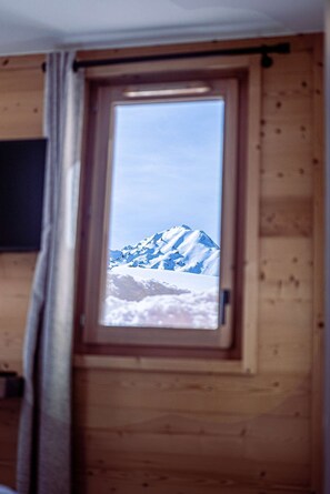 Ein Fenster mit Blick auf einen schneebedeckten Berg.