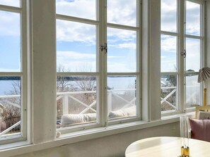 A room with large windows, a white table, and a view of a body of water. - 5 Star Holiday Home in Dalaro (Dalaro)
