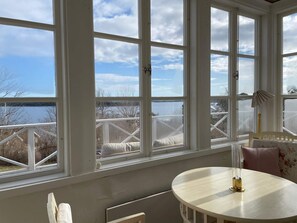 A room with large windows, a round table, and a view of a body of water. - 5 Star Holiday Home in Dalaro (Dalaro)