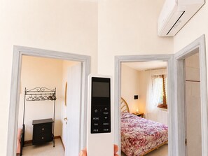 Ein Hotelzimmer mit Bett, Nachttisch, Kleiderschrank und Klimaanlage.
