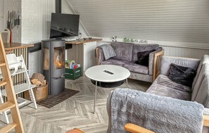 Ein gemütliches Wohnzimmer mit Kamin, einer Couch, einem Couchtisch und einem Fernseher.