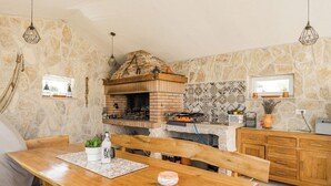 Eine rustikale Küche mit Backofen, Holzschränken und Steinwänden.