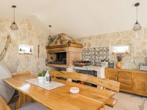 A rustic kitchen with a brick oven, wooden cabinets, and stone walls. - Villa Javor by Interhome (Pula/Krnica)