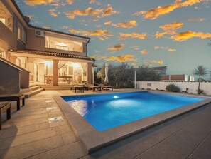 A swimming pool with a patio area, a covered outdoor seating area, and a stone facade building. - Villa Javor by Interhome (Pula/Krnica)