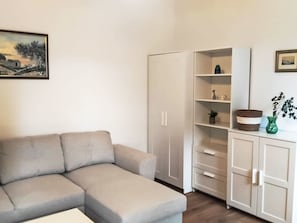 A living room with a sofa, a wardrobe, and a cabinet with shelves. - mit riesigem Garten by Interhome (Trogir/Seget Donji)