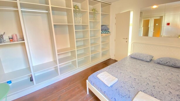 Ein Schlafzimmer mit Bett, Kleiderschrank und Spiegel.