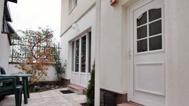 A clean, tiled patio area with a door, steps, and a small plant. - Geräumiges Ferienhaus mit kleinem Garten, nur fünf Gehminuten vom bekannten Bas by Interhome (Sarajevo)