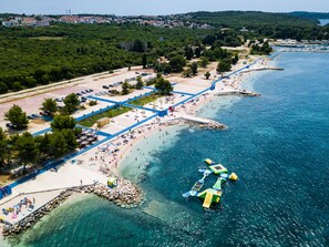 An aerial view of a coastal area with a beach, a parking lot, and a dock with boats. - Villa Rampic by Interhome (Fažana)