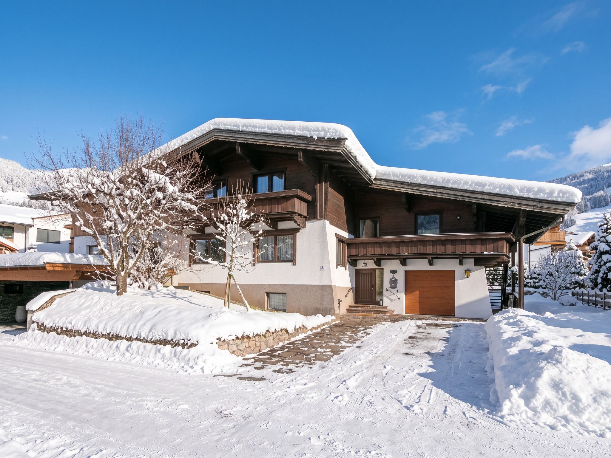 A chalet-style building with a sloped roof, wooden exterior, and a stone foundation.