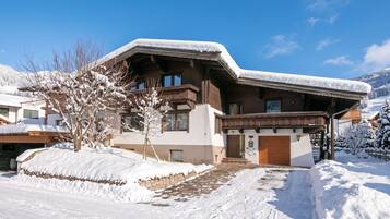 A chalet-style building with a sloped roof, wooden exterior, and a stone foundation.