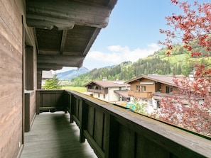 A wooden balcony with a view of houses and mountains. - Family Lodge in Kirchberg, 300m to the ski lift (Kirchberg in Tirol)