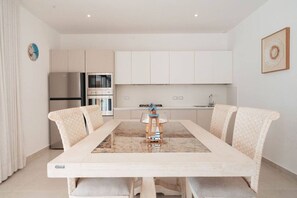 A modern kitchen with white cabinets, a built-in oven, and a stainless steel refrigerator. - 2BR/2.5BA Beachfront Condo | Sol de Arena B2 (Las Terrenas)