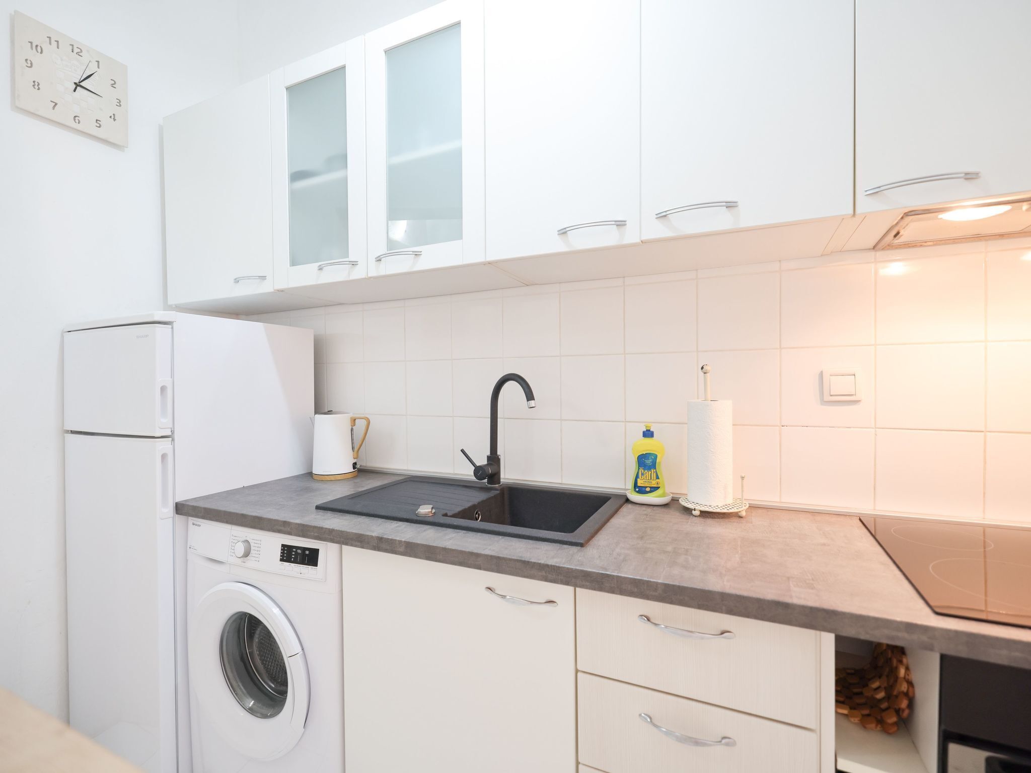 Een koelkast, een microgolfoven, een oven, kookgerei, borden en bestek
