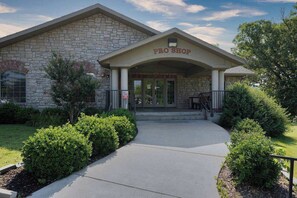 A building with a stone facade, a sign reading 'PRO SHOP,' and a covered entrance. - Patio on Pointe Royale Golf Course, Pools, Updated (Branson)