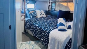 A compact RV interior with a bed, a small kitchenette, and a window. - My Time Boat House, Coconut Grove Miami (Miami)